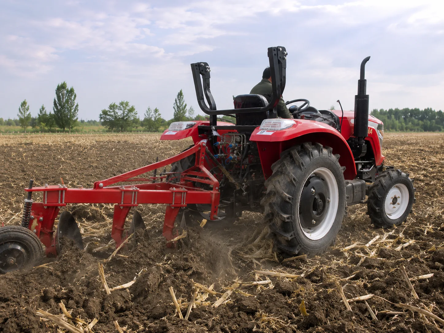 Arado de discos de tres discos montado en un tractor que remueve la tierra tras la cosecha.